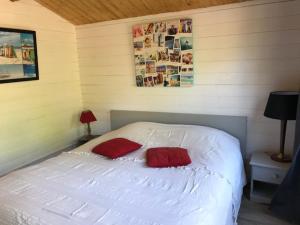 a bedroom with a white bed with two red pillows at la campagne de Mari in Peyrolles-en-Provence