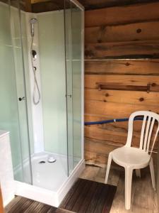 a bathroom with a glass shower and a chair at la campagne de Mari in Peyrolles-en-Provence