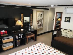 a bedroom with a bed and a couch and a television at House of Agnes in Canterbury