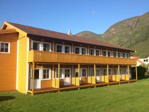 a large yellow building with a mountain in the background at Blix Hotel in Vikøyri