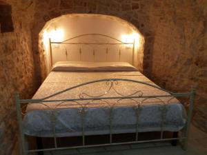 a bedroom with a metal bed with lights on it at Trulli Resort Grassi in Alberobello