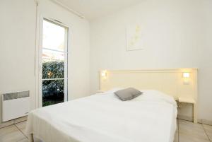- une chambre blanche avec un lit blanc et une fenêtre dans l'établissement Résidence Indigo II - Ocean Plage Résidences, à Biscarrosse-Plage