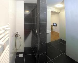 a bathroom with a shower with a black and white at Floli Gasthuis in Volendam