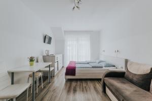a bedroom with a bed and a table and a couch at Chatka Morska 2 in Karwia