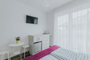 a bedroom with a bed and a table and a tv at Chatka Morska 2 in Karwia