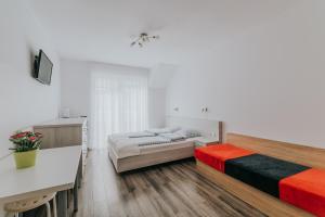 a bedroom with two beds and a desk and a television at Chatka Morska 2 in Karwia