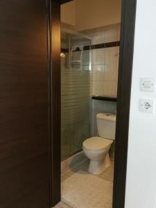 a bathroom with a toilet and a glass shower at SunnySun Studios in Faliraki