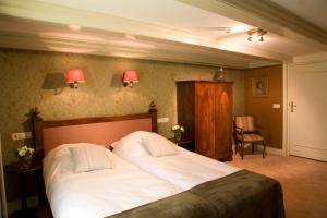 a bedroom with a large bed with white sheets at Stadspaleis Hotel & Restaurant OldRuitenborgh in Vollenhove