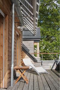 a white chair sitting on a deck next to a house at LeCoq-Gadby Hôtel & Spa, The Originals Relais in Rennes