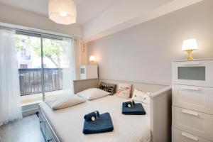 um quarto com uma cama com duas toalhas azuis em Welkeys - Rue Michelet Apartment em Biarritz