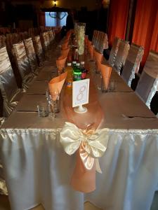 a long table with a white table cloth with a bow at Kanclera Hotel in Kaspichan