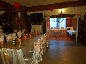 a room with a long table with white tables and chairs at Kanclera Hotel in Kaspichan
