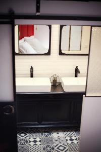 a bathroom with two sinks and two mirrors at equihome in Écommoy