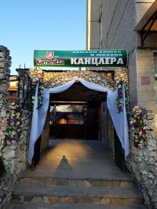 una entrada a un edificio con un arco y flores en Kanclera Hotel en Kaspichan