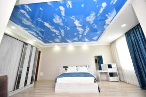 een slaapkamer met een blauw plafond bij Hotel Skyline Batumi in Batoemi