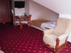 a hotel room with a bed and a table and chairs at Dworek Opartowo in Rajgród