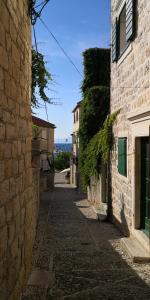 eine Gasse in einer Altstadt mit einem Steingebäude in der Unterkunft Apartments Jaksic in Postira