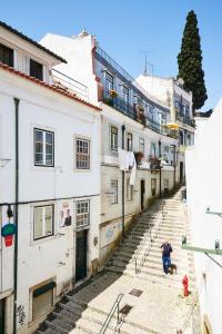 mężczyzna siedzący na schodach w alejce w obiekcie Casa com Alma Portuguesa @ Alfama w Lizbonie