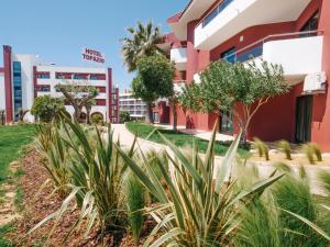 a building with plants in front of it at Topazio Vibe Beach Hotel & Apartments - Adults Friendly in Albufeira