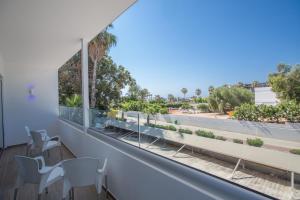 a balcony with chairs and a view of a street at Stratovarius Nissi Rooms in Ayia Napa