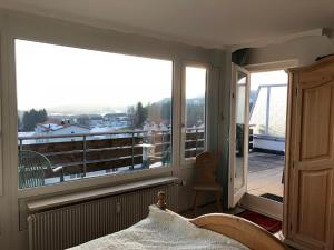um quarto com uma cama e uma varanda com vista em Rosenalm Penthouse 147 em Scheidegg