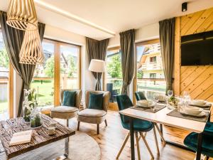 a living room with a table and chairs at TatryTop Rezydencja Zakopiańska SPA in Zakopane
