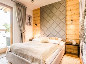 a bedroom with a large bed and a large window at TatryTop Rezydencja Zakopiańska SPA in Zakopane