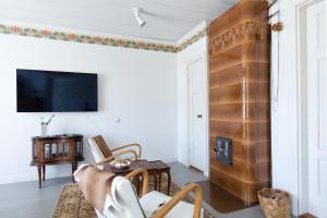 a living room with a fireplace and a tv at Matin ja Maijan Majatalo in Hämeenlinna