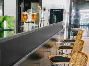 a bar with two chairs and a counter with drinks at Topazio Vibe Beach Hotel & Apartments - Adults Friendly in Albufeira