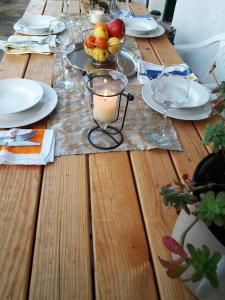 a wooden table with a candle and plates and glasses at Marty Apartment in Rogoznica +13 photos