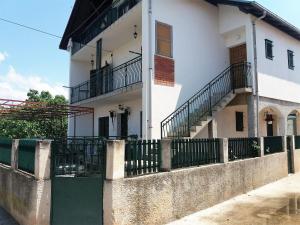 a white house with a fence in front of it at Marty Apartment in Rogoznica