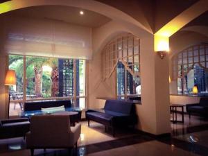 a lobby with couches and a table and windows at Palm Beach Skanes in Monastir