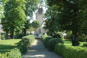 un chemin à travers un jardin avec un bâtiment en arrière-plan dans l'établissement La Palombiere, à Lucmau