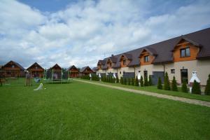 a row of houses with a playground in the grass at Atlanta Domki i Apartamenty in Ustronie Morskie
