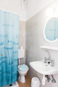 ein Badezimmer mit einem WC, einem Waschbecken und einem Spiegel in der Unterkunft Lefka Ori in Chora Sfakion