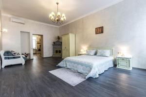ein großes Schlafzimmer mit einem Bett und einem Kronleuchter in der Unterkunft Dominicana l Apartments l Lviv Historical City Center in Lwiw