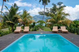 - une piscine avec 2 chaises longues et un complexe dans l'établissement Surf Tropical Villa Seascape, à Île au Cerf