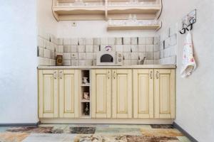 eine Küche mit gelben Schränken und einer Mikrowelle in der Unterkunft Dominicana l Apartments l Lviv Historical City Center in Lwiw + 26 Fotos