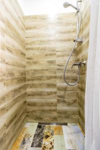 ein Bad mit einer Dusche und Holzwänden in der Unterkunft Dominicana l Apartments l Lviv Historical City Center in Lwiw