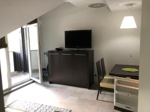 uma sala de estar com uma televisão e uma mesa com uma sala de jantar em Klass 302 em Kranjska Gora