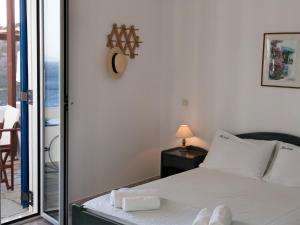 a bedroom with a bed and a sliding glass door at Meltemi Tinos in Agios Romanos