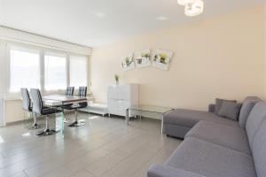 een woonkamer met een bank en een tafel bij Girasole by Quokka 360 - quiet two-bedroom apartment close to the centre in Lugano