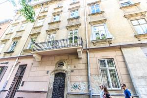 ein Gebäude in Paris mit Menschen, die davor spazieren gehen in der Unterkunft Dominicana l Apartments l Lviv Historical City Center in Lwiw