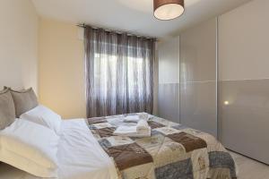 een slaapkamer met een bed en een raam bij Girasole by Quokka 360 - quiet two-bedroom apartment close to the centre in Lugano
