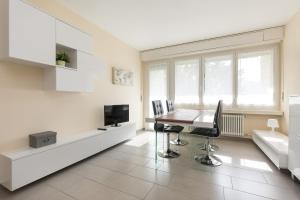 een eetkamer met een tafel en een tv bij Girasole by Quokka 360 - quiet two-bedroom apartment close to the centre in Lugano