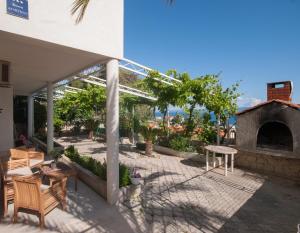 a patio with a fireplace and a table and chairs at Apartment Raquil in Split