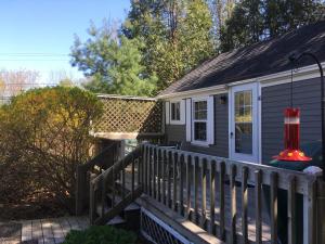 un porche de una casa con terraza de madera en Pine Grove Cottages, en Lincolnville