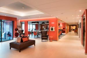 ティオンヴィルにあるDomitys Le Pavillon de Dianeのオレンジ色の壁のリビングルーム(ソファ、椅子付) +11枚の写真