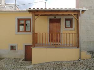 a house with a balcony with a wooden door at Casa do Terreiro in Macedo de Cavaleiros