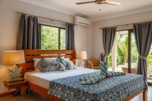 um quarto com uma cama com uma colcha azul e janelas em Surf Tropical Villa Seascape em Cerf Island